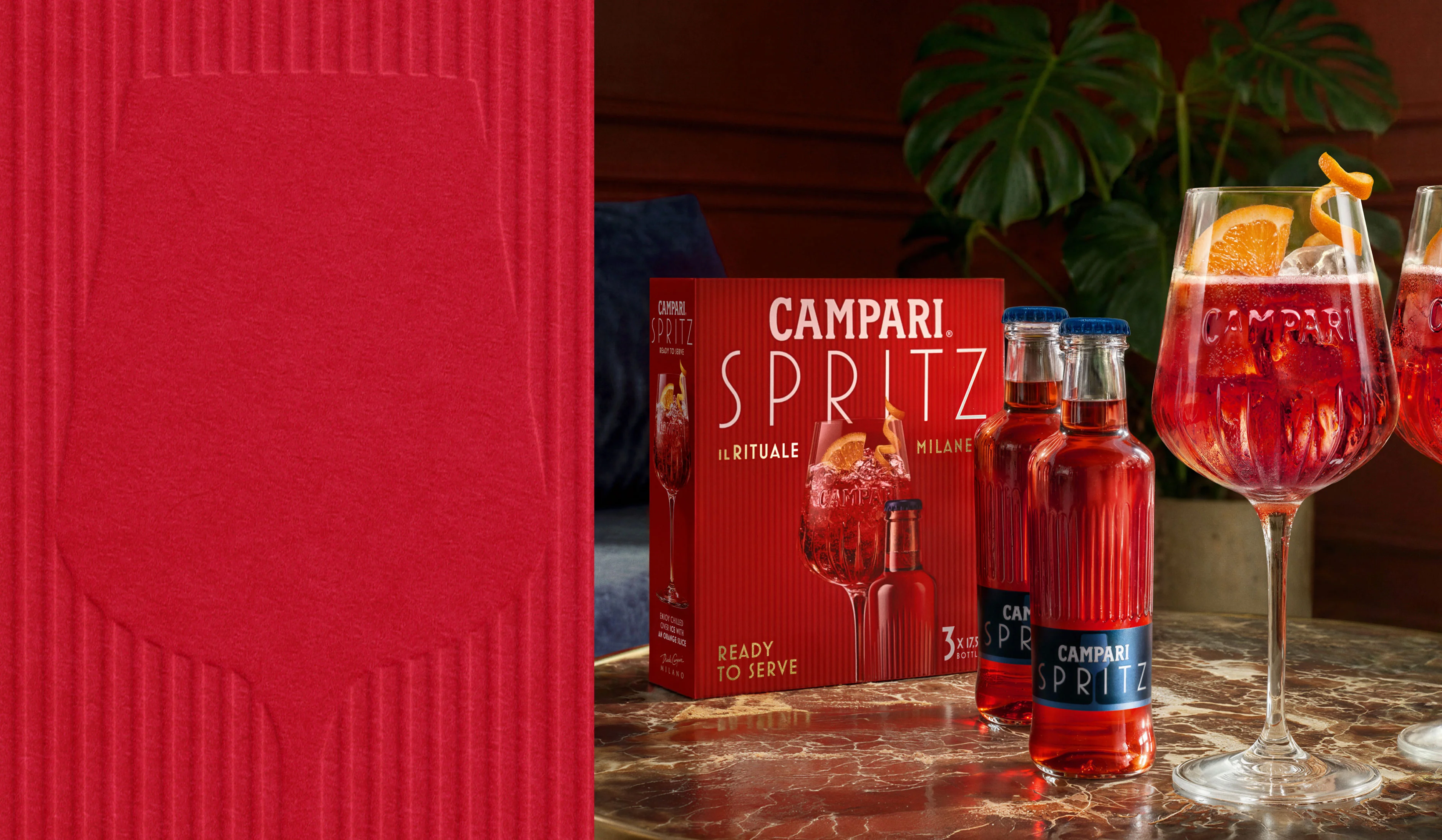 Campari Spritz ready-to-serve bottle, glass and gift box on a red background